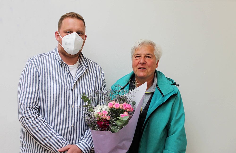 Übergabe eines Blumenstraußes an eine Knoop Mitarbeiterin